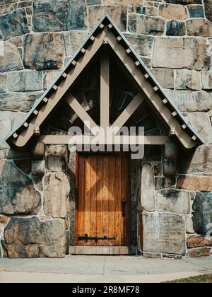 Eine Vertikale einer alten Holztür eines Steingebäudes Stockfoto