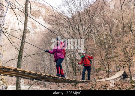 Eine Frau mit ihrem Teenager überquert den Canyon auf einer Hängebrücke Stockfoto