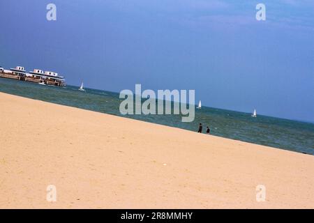 Tauchen Sie ein in die Schönheit eines malerischen Strandes, während der goldene Sonnenuntergang ein faszinierendes Licht über die ruhige Landschaft wirft Stockfoto