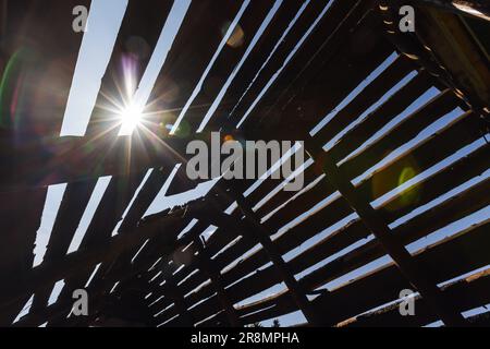 Die Sonne scheint durch ein verlassenes Dachgeschoss, Foto mit natürlichem Lichtreflexeffekt Stockfoto