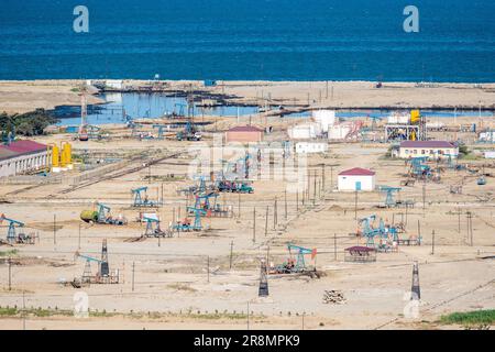 Onshore-Ölfeld mit Derrickpumpen an der Kaspischen Küste in Aserbaidschan. Stockfoto