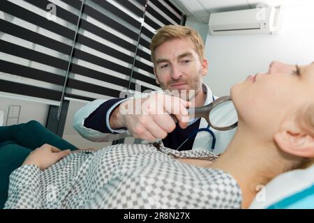 Eine Dermatologin untersucht eine Patientin Stockfoto