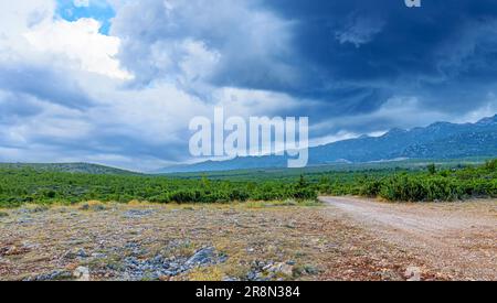 Die Gewitterwolken sammeln sich über den Bergen. Stockfoto