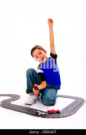 Junge mit Rennstrecke, Daumen hoch, Daumen hoch, Handzeichen, Spielzeug, Spiel, carrera-Titel Stockfoto