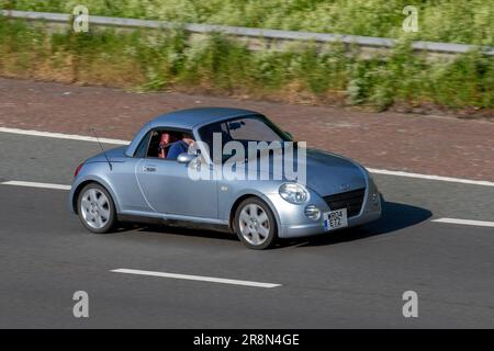 2004 Daihatsu Copen, flippiges kleines Cabrio, 2-türiges Kei-Auto mit Metallfaltdach, auf der Autobahn M6 im Großraum Manchester, Großbritannien Stockfoto