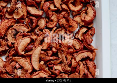 Ein lebhaftes und appetitliches Gericht mit verschiedenen getrockneten Äpfeln, kunstvoll in einer Keramikschüssel angeordnet Stockfoto