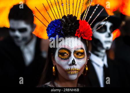 Eine mexikanische Frau, die als La Catrina verkleidet ist, und mexikanische Männer, die als Catrín verkleidet sind, nehmen an den Feierlichkeiten zum Tag der Toten in Morelia, Mexiko, Teil. Stockfoto