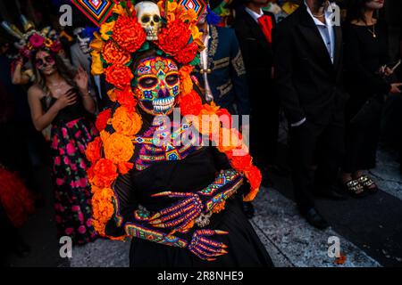 Eine Mexikanerin, die als La Catrina verkleidet ist und Huichol Perlenmaske und -Kleid trägt, nimmt an den Feierlichkeiten zum Todestag in Morelia, Mexiko, Teil. Stockfoto