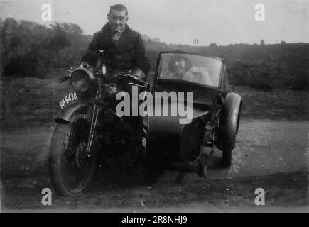 Snapshot, ein Mann auf einem Motorrad mit einer Begleiterin im Beiwagen, c1920er. Aus einer Sammlung von persönlichen Fotos, von denen viele nicht detailliert kommentiert wurden. Die unbenannte Familie stammt aus Witley, einem kleinen Dorf in Waverley und in der Nähe von Godalming in Surrey, England. Stockfoto