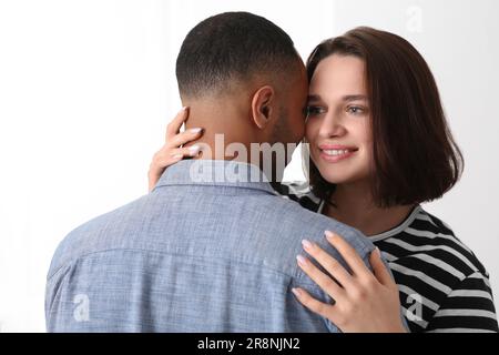 Dating-Agentur. Eine Frau, die ihren Freund auf weißem Hintergrund umarmt Stockfoto