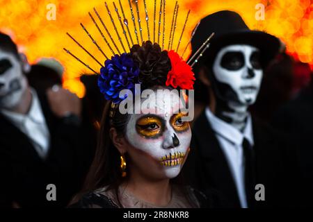 Eine mexikanische Frau, die als La Catrina verkleidet ist, und mexikanische Männer, die als Catrín verkleidet sind, nehmen an den Feierlichkeiten zum Tag der Toten in Morelia, Mexiko, Teil. Stockfoto
