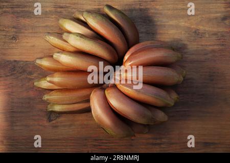 Leckere lila Bananen auf einem Holztisch, Blick von oben Stockfoto