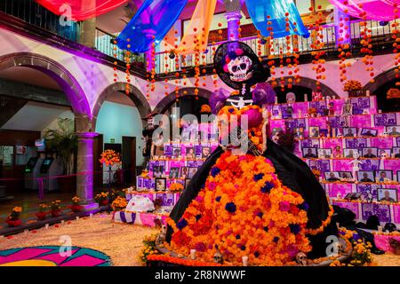 Die Figur La Catrina wird während der Totenfeier in Tlaquepaque, Mexiko, vor dem Altar der Toten (Altar de Muertos) platziert. Stockfoto