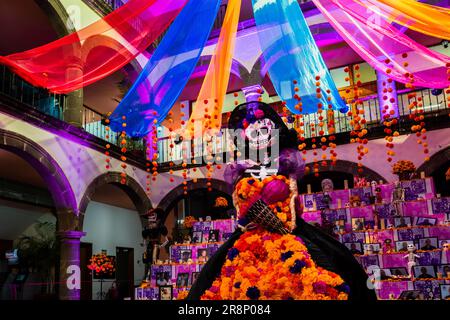 Die Figur La Catrina wird während der Totenfeier in Tlaquepaque, Mexiko, vor dem Altar der Toten (Altar de Muertos) platziert. Stockfoto