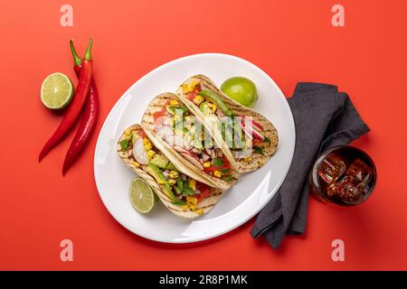 Mexikanische Küche mit Tacos mit Fleisch und gegrilltem Gemüse. Flach über Rot gelegt Stockfoto