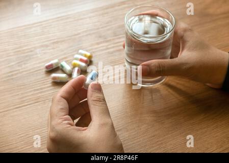 Menschen, die Medikamente mit einem Glas Trinkwasser einnehmen. Stockfoto