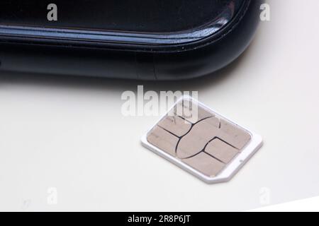 Berlin, Deutschland. 22. Juni 2023. Eine SIM-Karte liegt auf einem Tisch neben einem Smartphone. Kredit: Fernando Gutierrez-Juarez/dpa/Alamy Live News Stockfoto