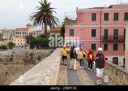 ALGHERO, ITALIEN - 29. MAI 2023: Die Menschen nehmen an einer Stadtbesichtigung bei Regen Teil. Alghero Stadt auf der Insel Sardinien, Italien. Stockfoto