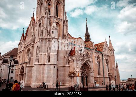 Eine Gruppe von Personen versammelt sich auf dem platz vor einer majestätischen Kathedrale Stockfoto