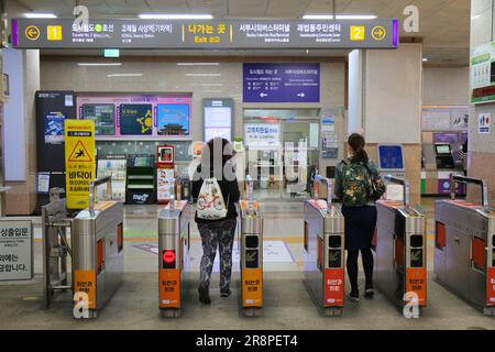 BUSAN, SÜDKOREA - 30. MÄRZ 2023: Passagiere betreten die Busan U-Bahn-Station mit automatischen Ticketschaltern in Südkorea. Stockfoto