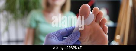 Orthopäde, die ein Korsett für Hallux Valgus bei weiblichen Patienten aufbringt Stockfoto