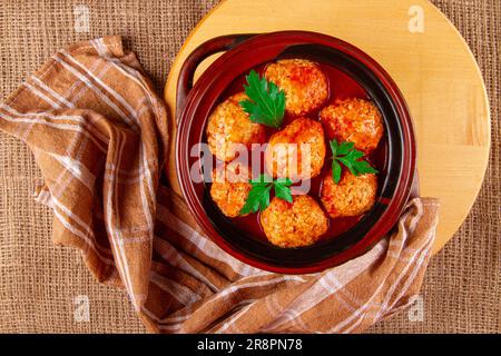 Tonpfanne mit frisch zubereiteten Kottbular-Fleischbällchen in roter Sauce Stockfoto