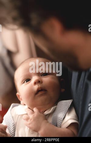 Das unschuldige Gesicht eines Babys blickt direkt in die liebevollen Augen seines Vaters und bildet eine unzerbrechliche Bindung. Stockfoto