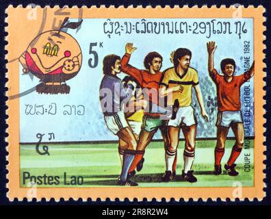 LAOS - UM 1982: Eine in Laos gedruckte Marke zeigt Fußballspieler in Aktion, 1982 WM-Fußballmeisterschaften, Spanien, um 1982 Stockfoto