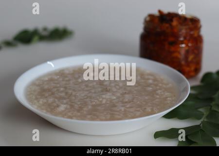 Kanji und Kadumanga. Reismehl mit Kerala Matta Reis. Aufgenommen mit Kerala-Mango-Gurke auf weißem Hintergrund. Stockfoto