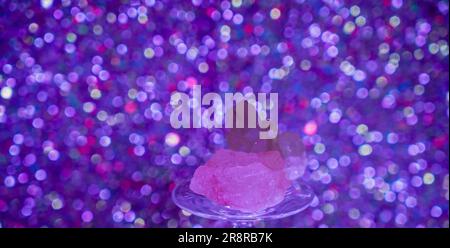 Amethyst Druze Quartz vor blauem Hintergrund auf Glas im Studio Stockfoto