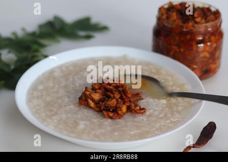 Kanji und Kadumanga. Reismehl mit Kerala Matta Reis. Serviert mit Kerala-Mango-Gurke. Auf weißem Hintergrund aufgenommen. Stockfoto