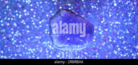 Amethyst Druze Quartz vor blauem Hintergrund auf Glas im Studio Stockfoto