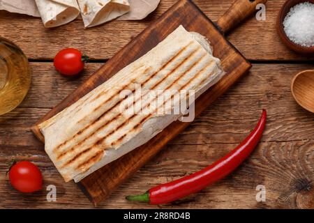 Leckeres Schawarma mit Tomaten auf Holzhintergrund Stockfoto