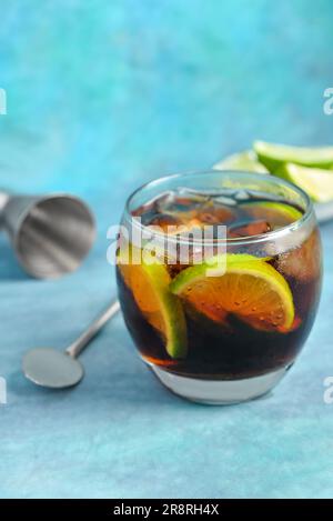 Ein Glas kalten Cuba Libre Cocktail auf blauem Hintergrund Stockfoto