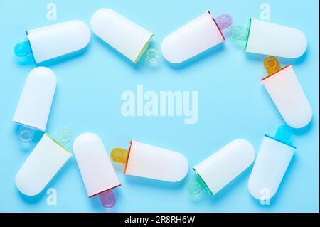 Eisformen liegen wie ein Rahmen auf der zyanblauen Oberfläche Stockfoto