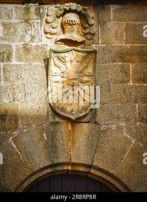 Eine Steinschnitzerei eines alten heraldischen Schilds über dem Eingang eines Palastes in Spanien Stockfoto