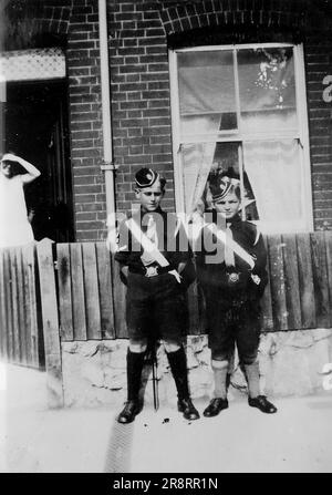 Zwei Jungs stehen vor einem Haus, in Uniform der Boy's Brigade. Dies ist ein Foto aus einem Album, das hauptsächlich Schnappschüsse aus dem Jahr c1929 während der Besetzung Palästinas durch die britische Armee enthält, mit Fotos aus Palästina und Großbritannien, darunter Devil's Jump Near Churt in Surrey und Devil's Punch Bowl. Das Training scheint im Hursley Camp bei Winchester zu sein. Zwischen 1920 und 1948 verwaltete Großbritannien Palästina im Namen des Völkerbundes, ein Zeitraum, der als "britisches Mandat" bezeichnet wird. Stockfoto