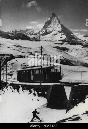 Selbstfahrende Züge verkürzen die Reisezeit auf Schweizer Eisenbahnen -- das majestätische Matterhorn bildet einen imposanten Hintergrund für einen der beiden neuen selbstfahrenden Züge, die auf der Strecke zwischen Zermatt und Cornergrath in Betrieb genommen wurden. Die Kutschen, die 110 Passagiere befördern, schaffen die Strecke in 45-50 Minuten, 25 Minuten weniger als die von der Lokomotive gezogenen Züge. Die neuen Wagen - die ersten wurden 1947 auf der Strecke eingeführt - kosten jeweils ca. 360.000 Francs. 21. April 1952. Stockfoto