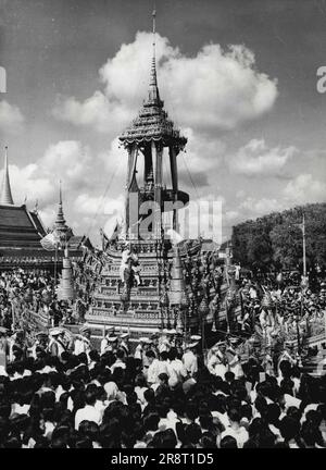 Die Trauerprozession des verstorbenen Königs von Thailand - die königliche Grabkutsche Maha Pichai mit der Urne, die die Überreste des verstorbenen Königs Phra ParAmenr Maha Ananda Mahidol Sayamindradiraj von Thailand enthält - die 1946 starb - bewegt sich langsam durch die Straßen von Bangkok, 29. März, Auf dem Weg zum Phra Meru (königlicher Einäscherungsstand). 200 Mitglieder der Armee, der Marine und der Luftwaffe ziehen die Kutsche. Solche Leichenwagen, wie hier zu sehen ist, sind schwere und sperrige Fahrzeuge mit einem Gewicht von etwa 40 Tonnen. 31. März 1950. (Foto nach zugehörigem Pressefoto). Stockfoto