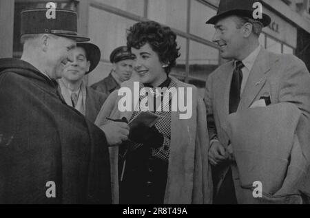 Elizabeth Taylor auf ihrer Hochzeitsreise - Elizabeth Taylor und Michael Wilding bei ihrer Ankunft im Le bourget. Sie geben ihre Autogramme einem Polizisten. Elizabeth Taylor und Michael Wilding, die letzten Donnerstag verheiratet waren, haben in Paris ihre Flitterwochen verbracht. Die neue Mrs. Wilding ist 19 und ihr Mann 39. 25. Februar 1952. (Foto: Paul Popper, Paul Popper Ltd.) Stockfoto