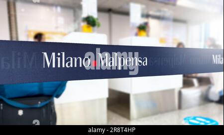 Malpensa, Italien, Juni 21 2023: Blaue, einziehbare Gurtschranke mit weißem Logo des Flughafens Mailand-Malpensa. Italienischer internationaler Flughafen in der reg Stockfoto