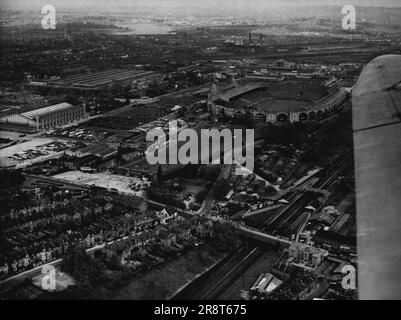 Wembley - Zentrum der 1948 Olumpics - Dies ist ein Luftblick auf das Stadion in Wembley mit geräumigen Sitzgelegenheiten und Parkplätzen. Die neue Straße ist größtenteils verdeckt, sie verläuft auf der anderen Seite des Stadions. Der Empire-Pool, in dem die Schwimmveranstaltungen stattfinden, befindet sich links vom Bild, auf der anderen Seite der Parkplätze vom Stadion aus. Wembley, England, das bekannte Sportzentrum des britischen Imperiums, wird Schauplatz der Eröffnungszeremonie der XIV. Olympiade, London, 1948 sein, wenn die brennende Fackel aus dem Dorf Olympia, Südgriechenland, im berühmten Sportstadion eintrifft… Stockfoto