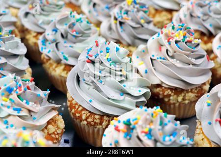 rainbow Frosted Vanille Aroma Cupcake oder Muffin mit Streuseln Stockfoto