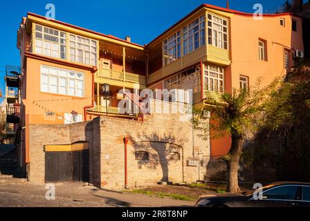 Georgia, Tiflis - 28. November 2020: Häuser mit Balkonen im historischen Stadtteil Tiflis. Georgien. Abendliche Aussicht. Wunderschöne Altstadt bei Sonnenuntergang. Stockfoto