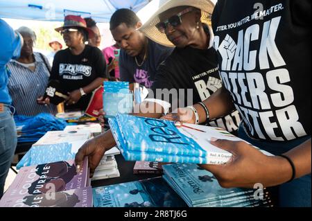 Fort Lauderdale, Florida, USA. 22. Juni 2023. Atendeen der NAACP Stay Woke Florida Rolling Votercade Rally erhalten eine kuratierte Auswahl an Büchern aus der Florida Banned Buchliste bei einem Buch-Geschenk im Fort Lauderdale African-American Cultural Center. Neben anderen Organisationen der sozialen Gerechtigkeit reiste die NAACP durch 15 Städte in Florida, um gegen die jüngsten Gesetze zu protestieren, das Bewusstsein zu schärfen und die Angehörigen anderer marginalisierter Gemeinschaften zu ermutigen, sich gegen Angriffe auf ihre Gemeinschaften und auf die Demokratie zu wehren. (Kreditbild: © Orit Ben-E Stockfoto