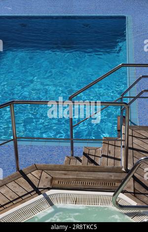 Der Aquarius Pool und einer von zwei Whirl Pools auf dem offenen Lido Deck hinter Deck 9 an Bord des P&O Vista Class Kreuzfahrtschiffes Arcadia, April 2023. Stockfoto