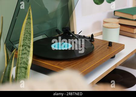 Eleganter Plattenspieler mit Schallplatte auf dem Tisch im Innenbereich Stockfoto