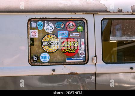 Detail des aufgeklebten Fensters eines weit gereisten und rostigen VW-Wohnwagens. Roadtrip, böhmischer Lifestyle oder Camping-Konzept. Stockfoto