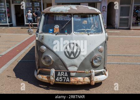 Ein weit gereister und rostiger Volkswagen-Wohnwagen. Vorderansicht eines verwitterten VW-Transporters mit seinem legendären WV-Emblem. Oldtimer- und Oldtimer-Show. Stockfoto