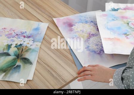 Eine Frau, die Blumen drinnen malt, eine Nahaufnahme. Aquarell-Bildmaterial Stockfoto